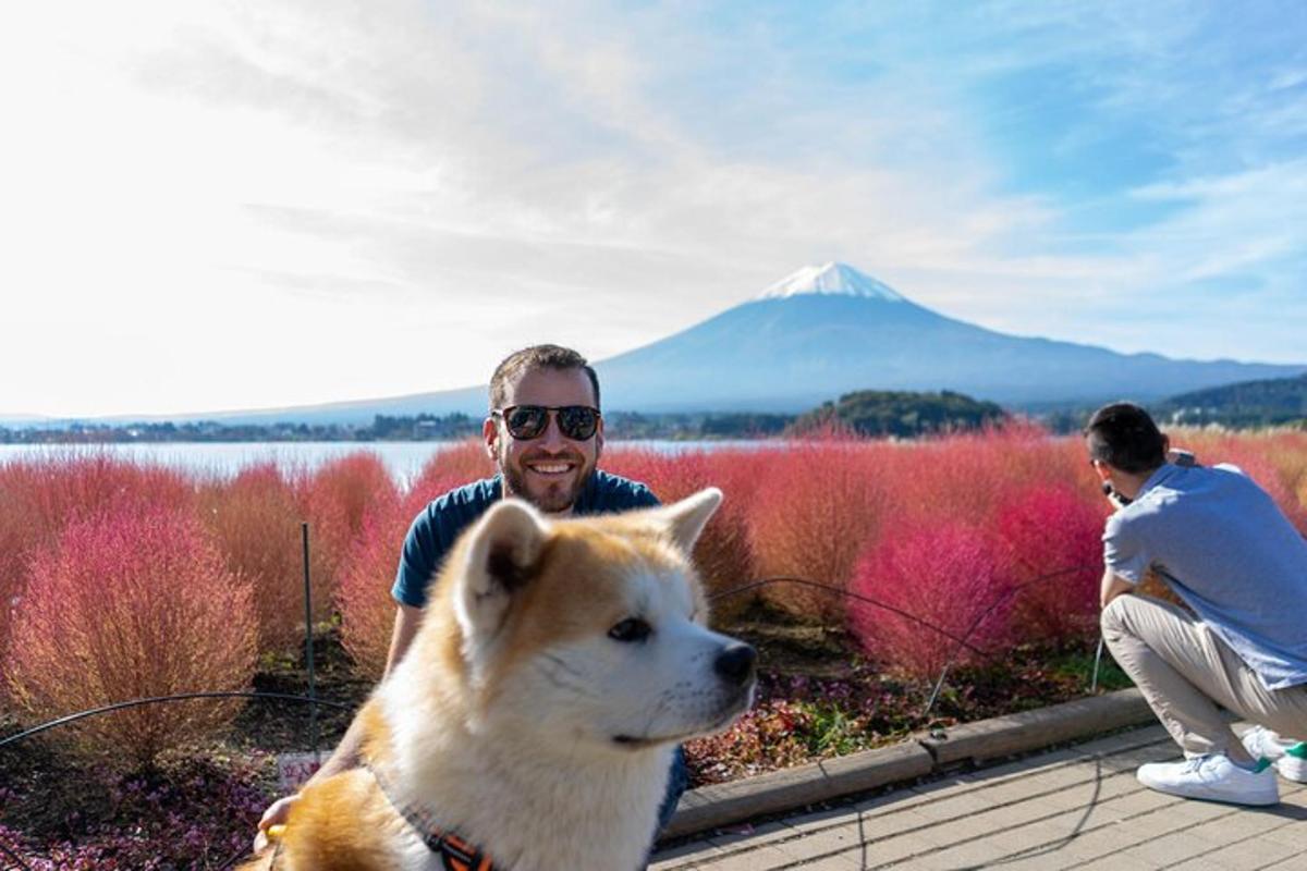 Un hombre y un perro con una montaña al fondo.
