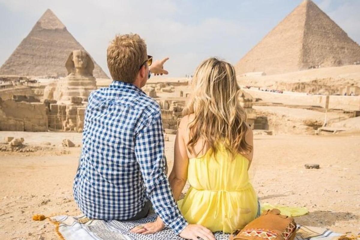 muž a žena sedící před pyramidami
