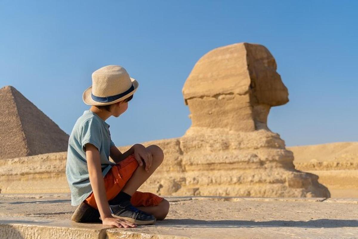 mladý chlapec sedící před pyramidami