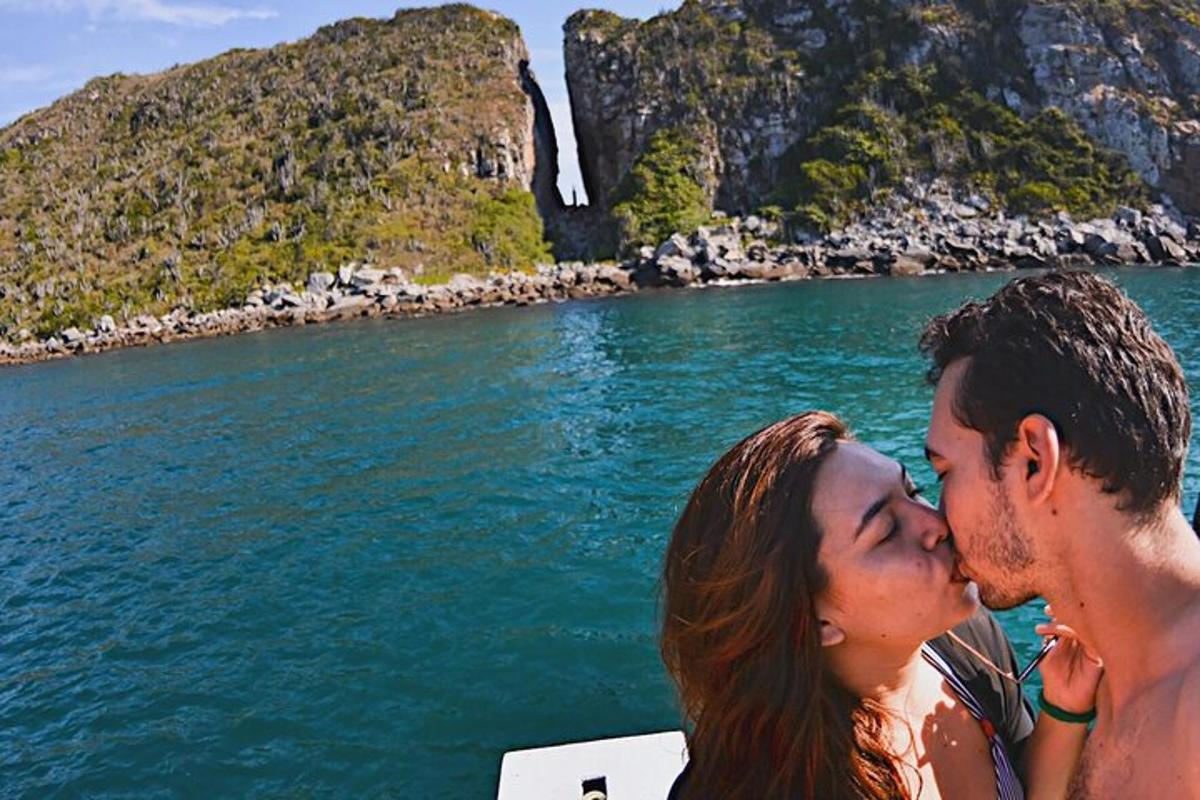 Un hombre y una mujer besándose en un barco en el agua