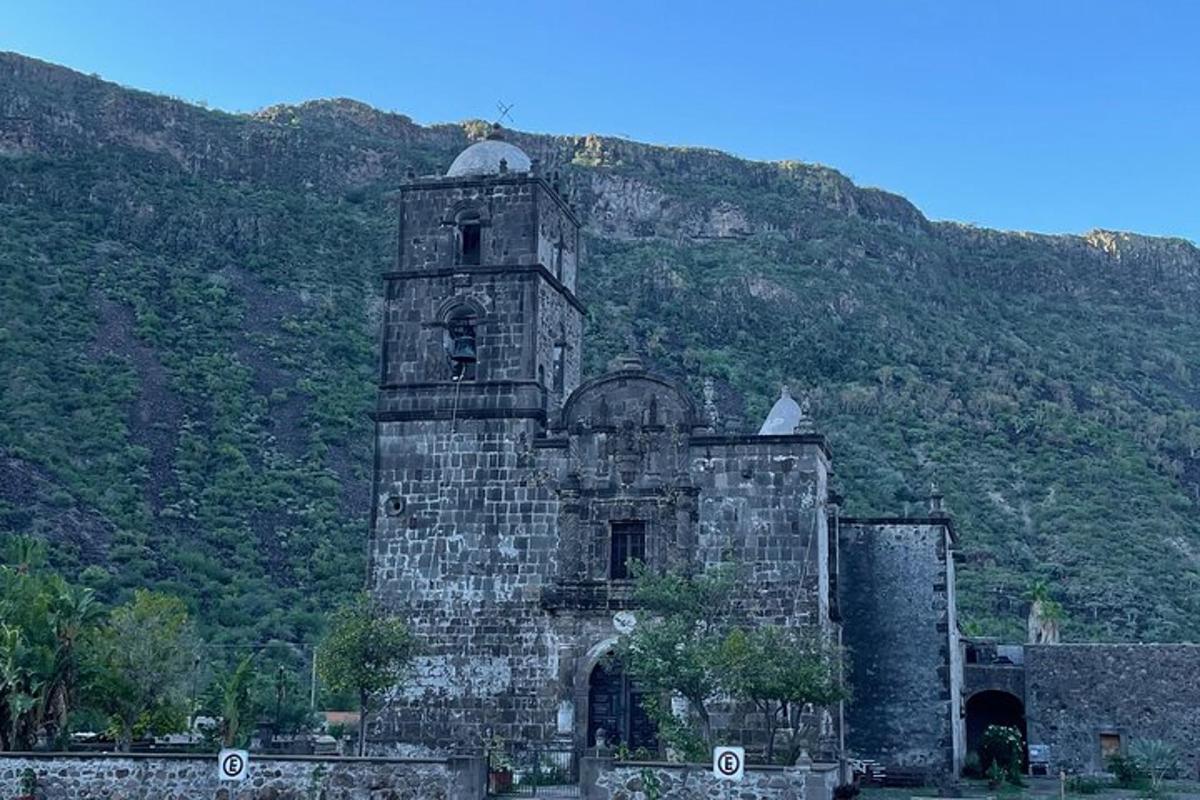 an old building in front of a mountain