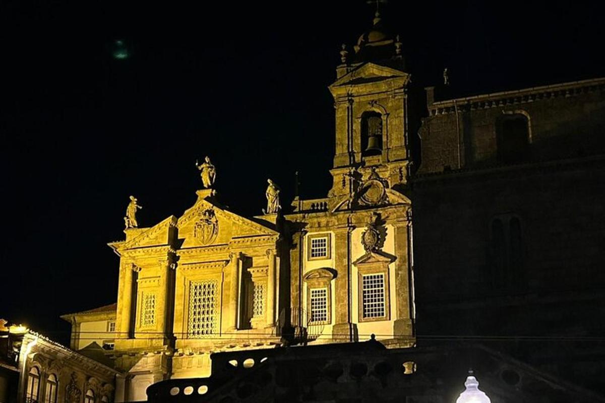 Un gran edificio con una torre de reloj por la noche.