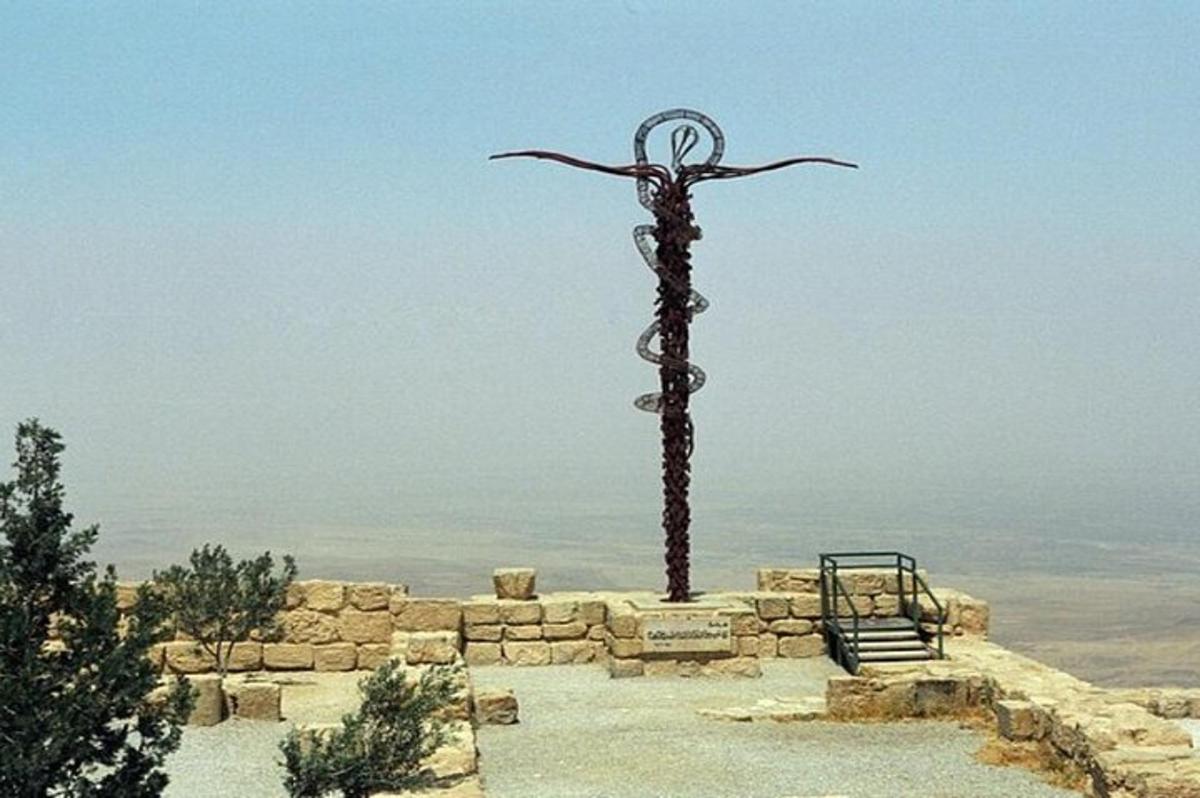 o statuie a unei cruci în vârful unui deal