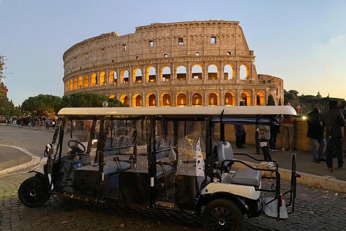 o căruță de golf parcată în fața Colosseumului