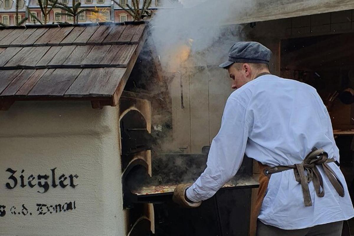 maður stendur fyrir framan pizzaofn