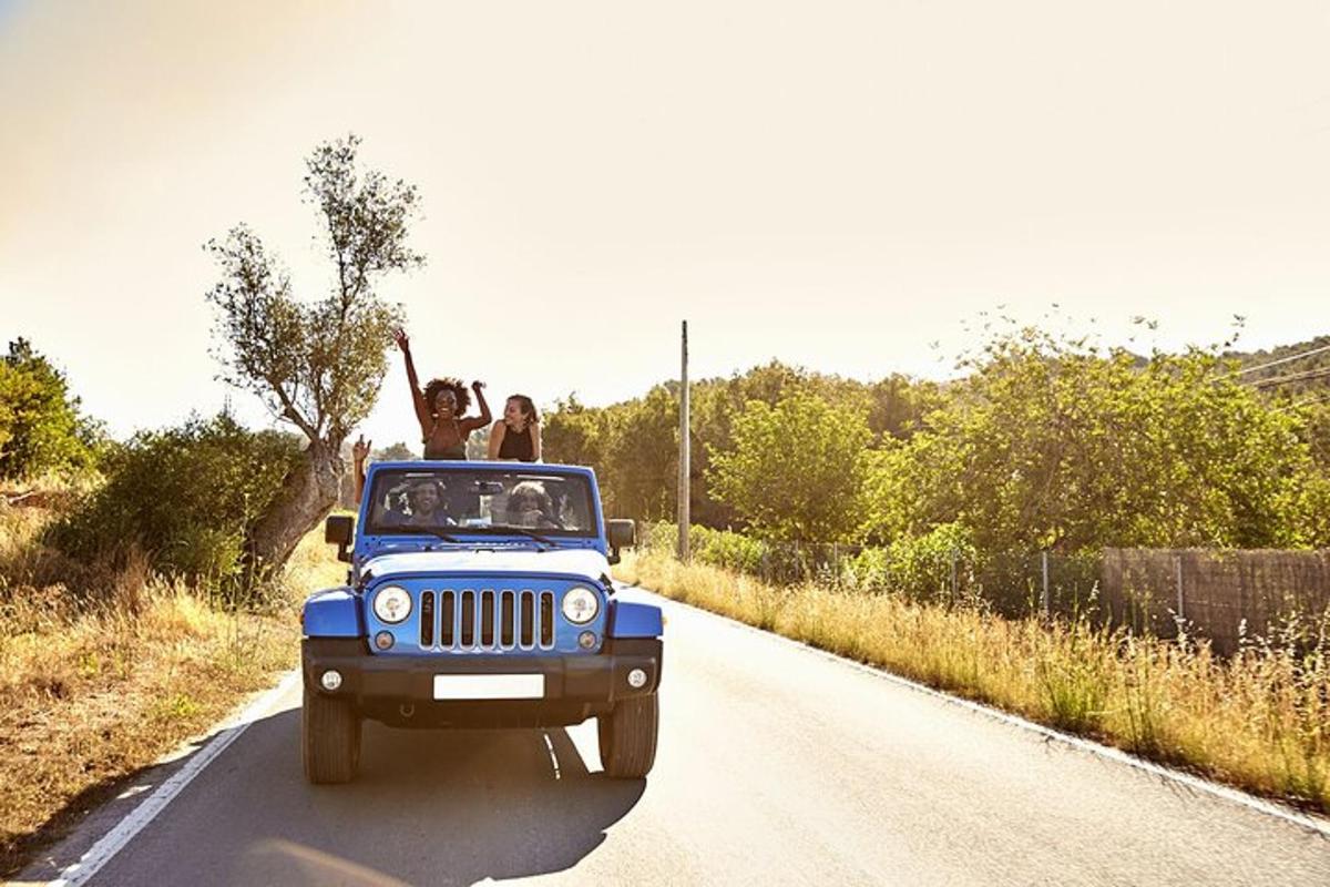 Dos personas en la parte trasera de un jeep en una carretera