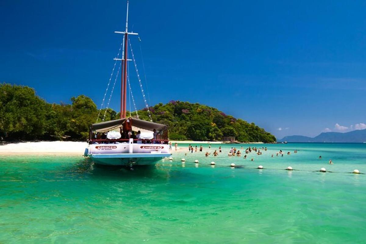 Un barco en el agua con gente en una playa.