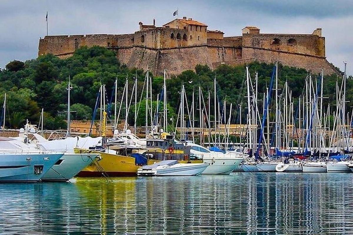 un gruppo di barche attraccate in un porto con un castello