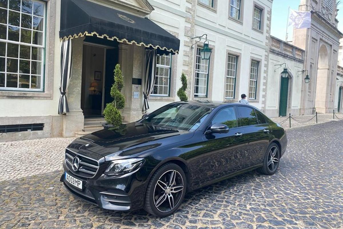 um carro preto estacionado em frente a um prédio