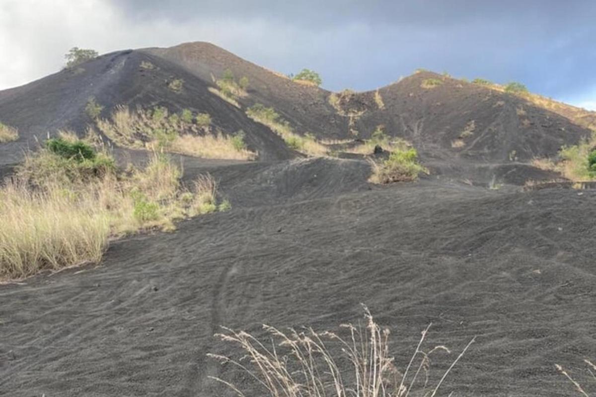 una collina sterrata con una montagna sullo sfondo