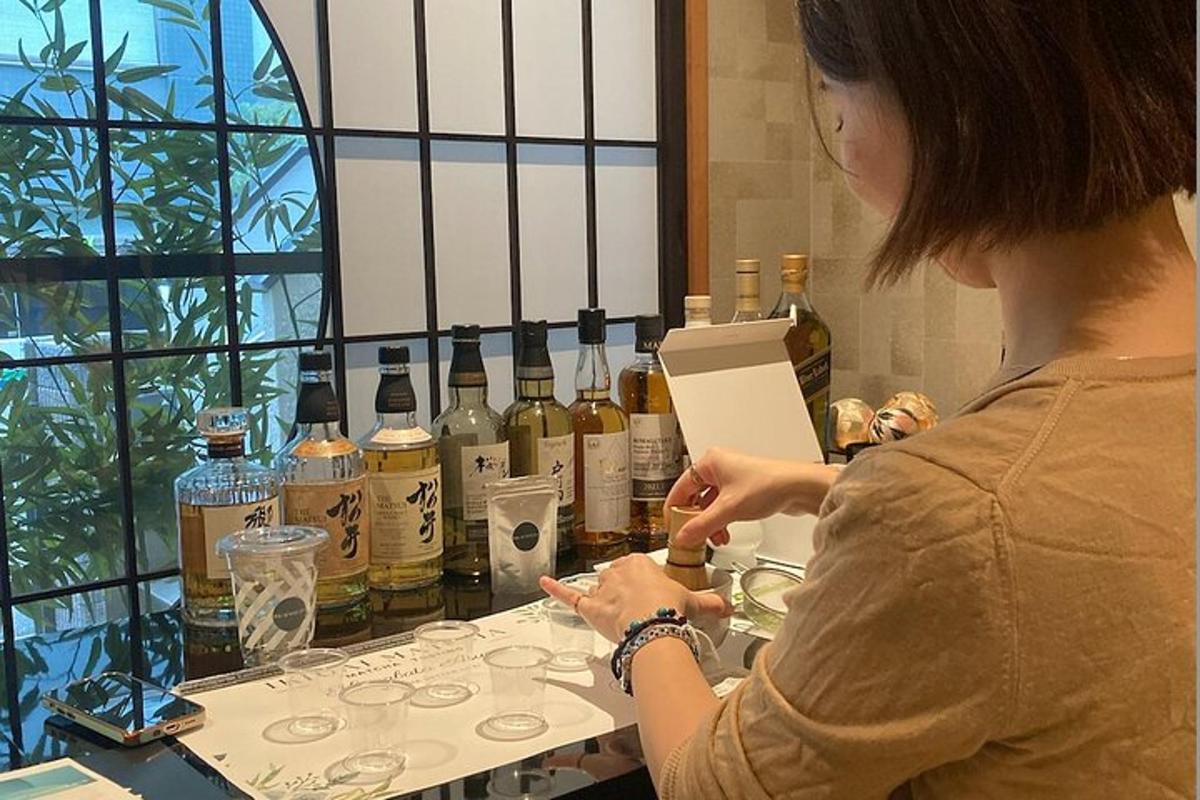 žena stojící před stolem s lahvemi alkoholu