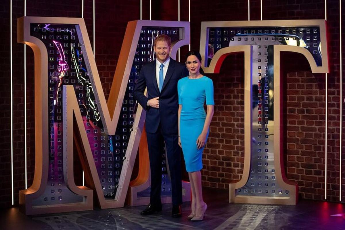 a man and woman standing in front of a large letter m