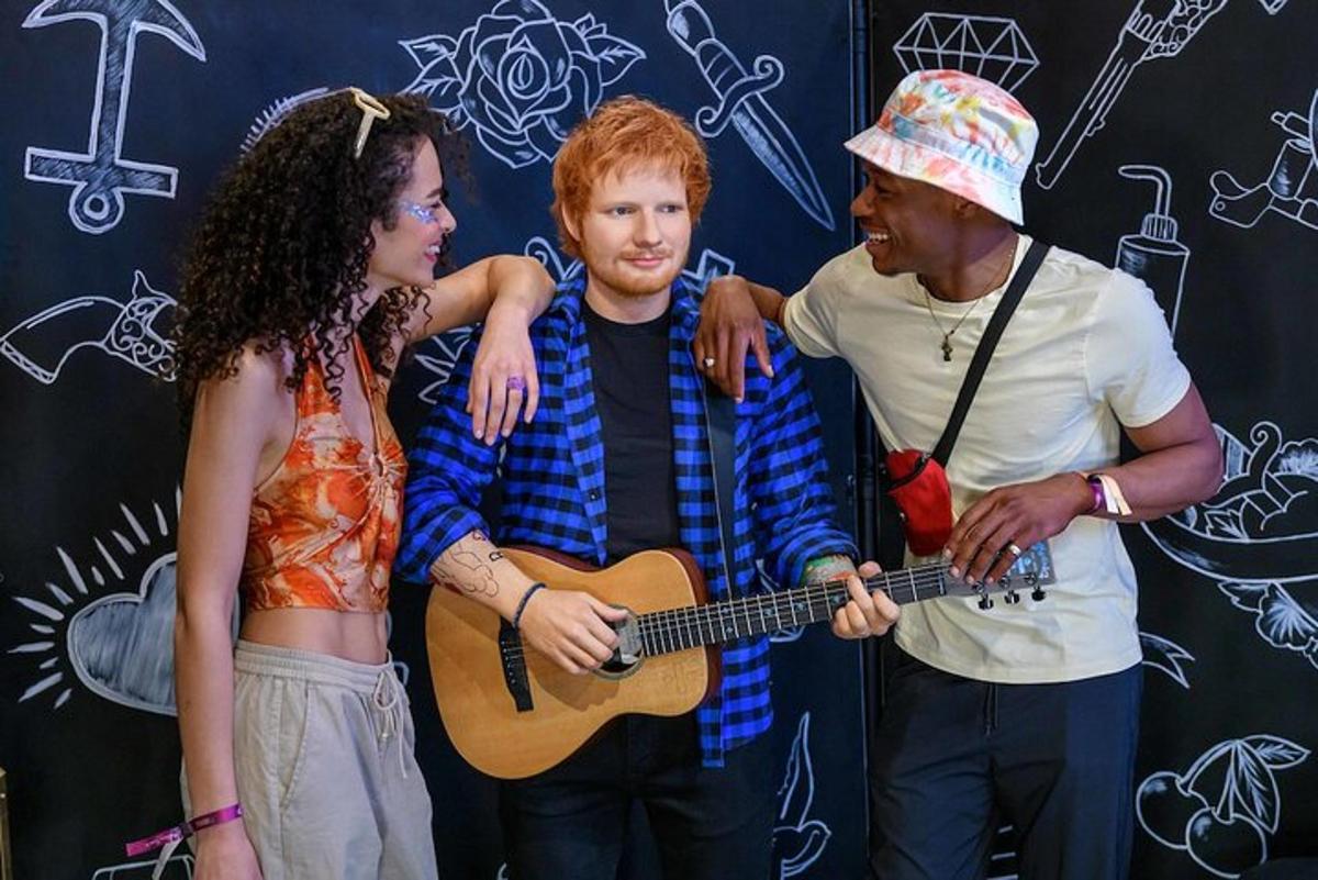 a group of people standing around a man playing a guitar