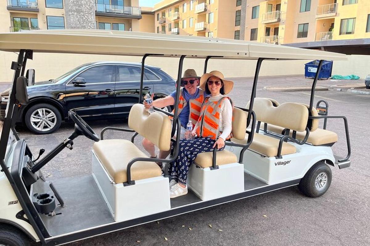 muž a žena sedící v golfovém vozíku