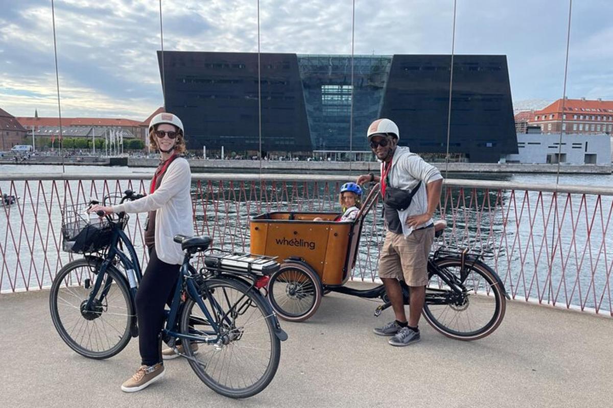 un uomo e una donna con un bambino su un carretto in bicicletta