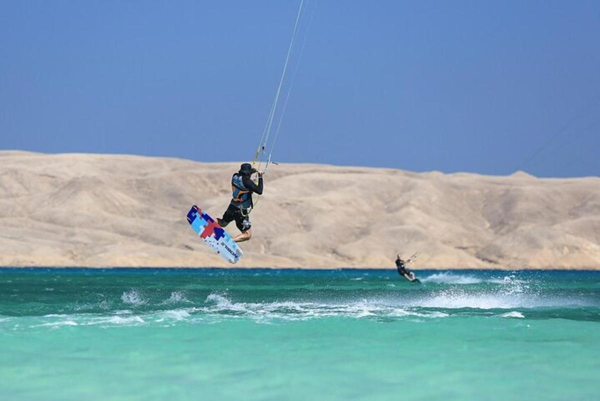 un uomo che vola in aria mentre fa kitesurf nell'oceano