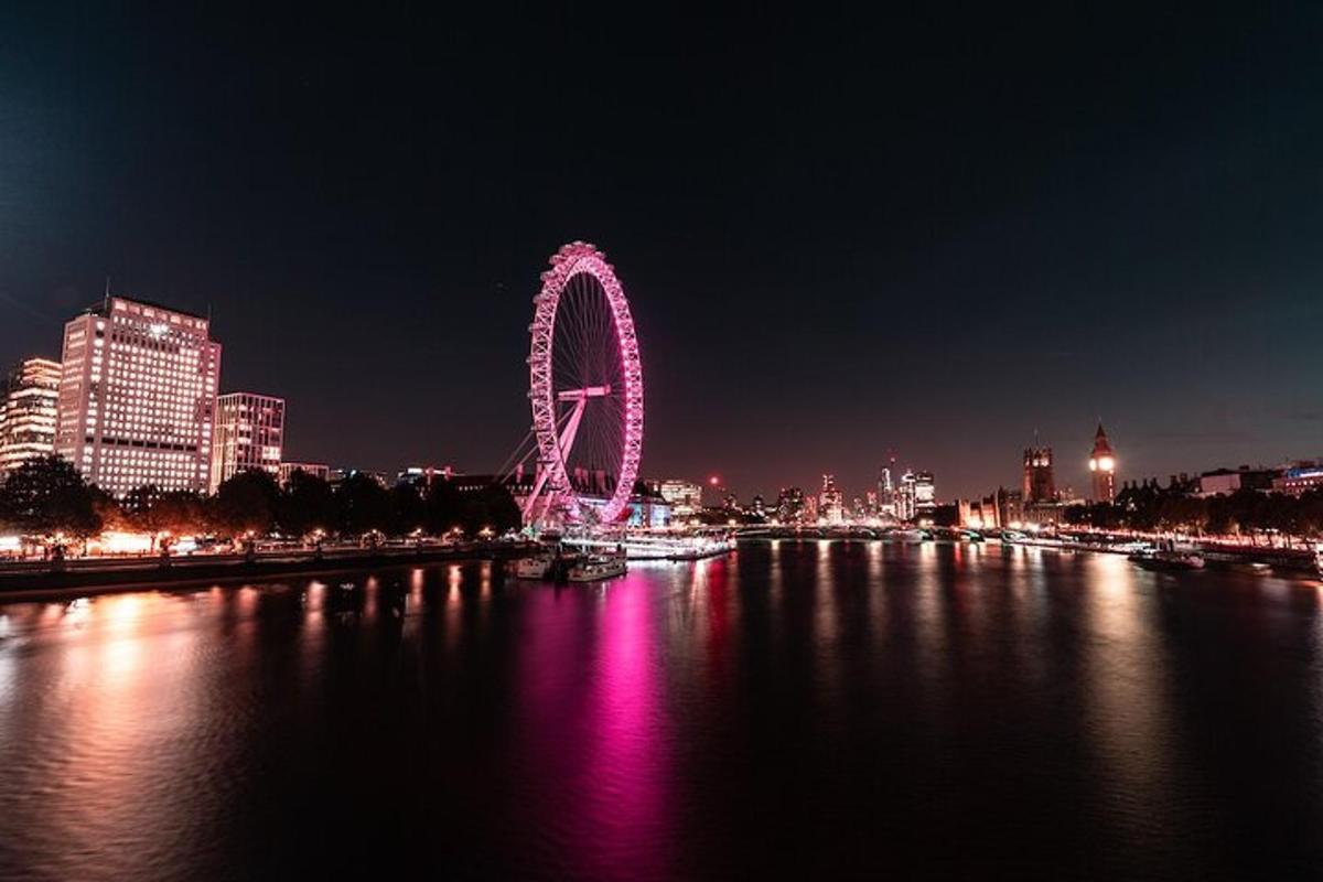 a ferris wheel lit up at night on the water