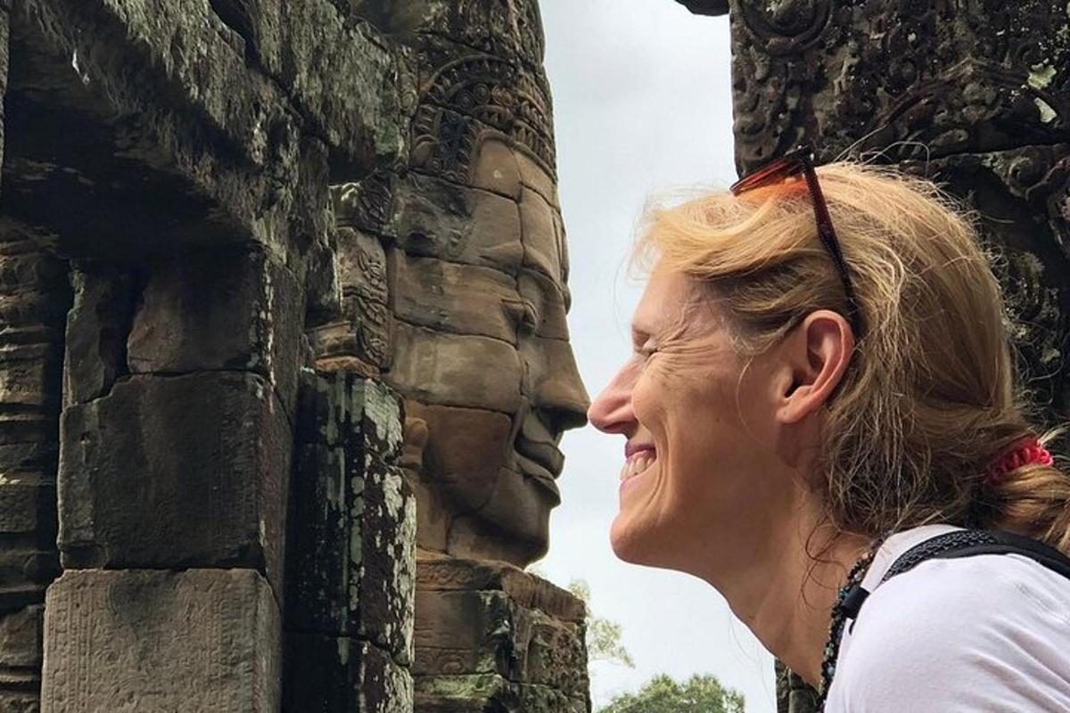 una mujer parada junto a un muro de piedra