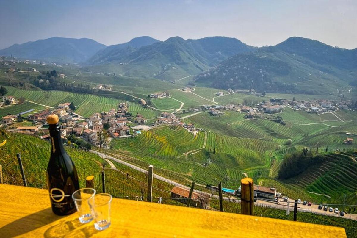 o sticlă de vin așezată pe o masă cu pahare de vin