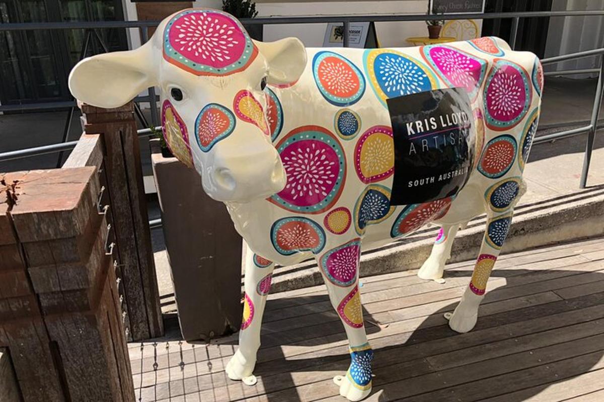 una statua di una mucca in piedi su un marciapiede