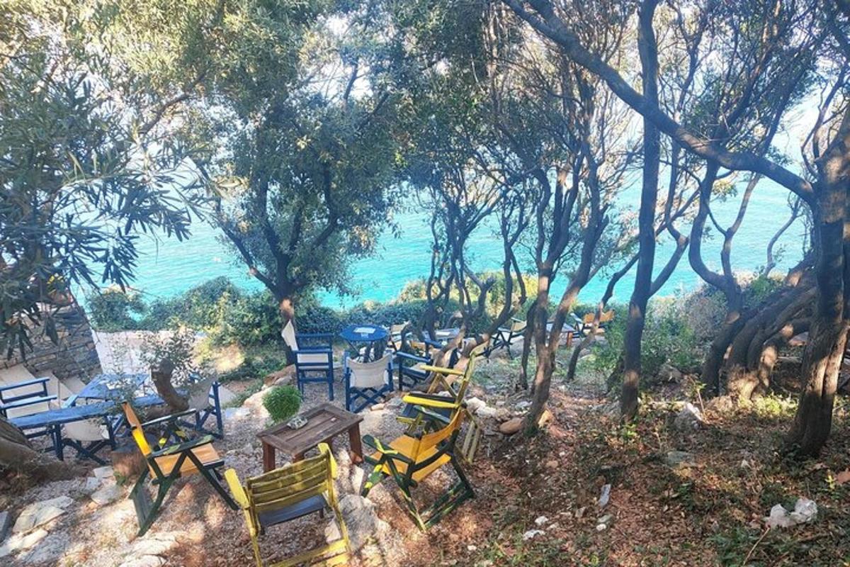 a group of tables and chairs in front of the water
