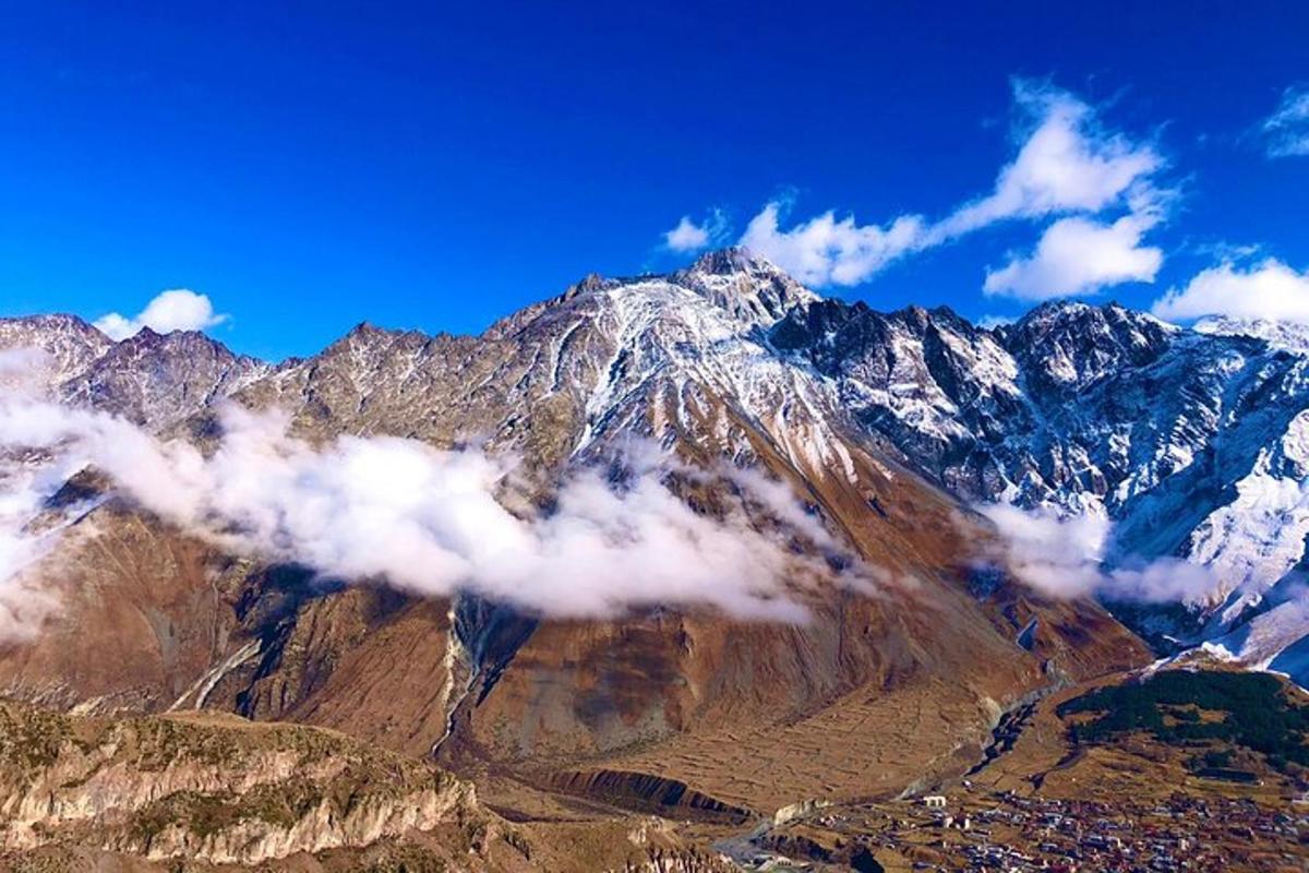 gunung yang dilitupi salji dan awan di langit