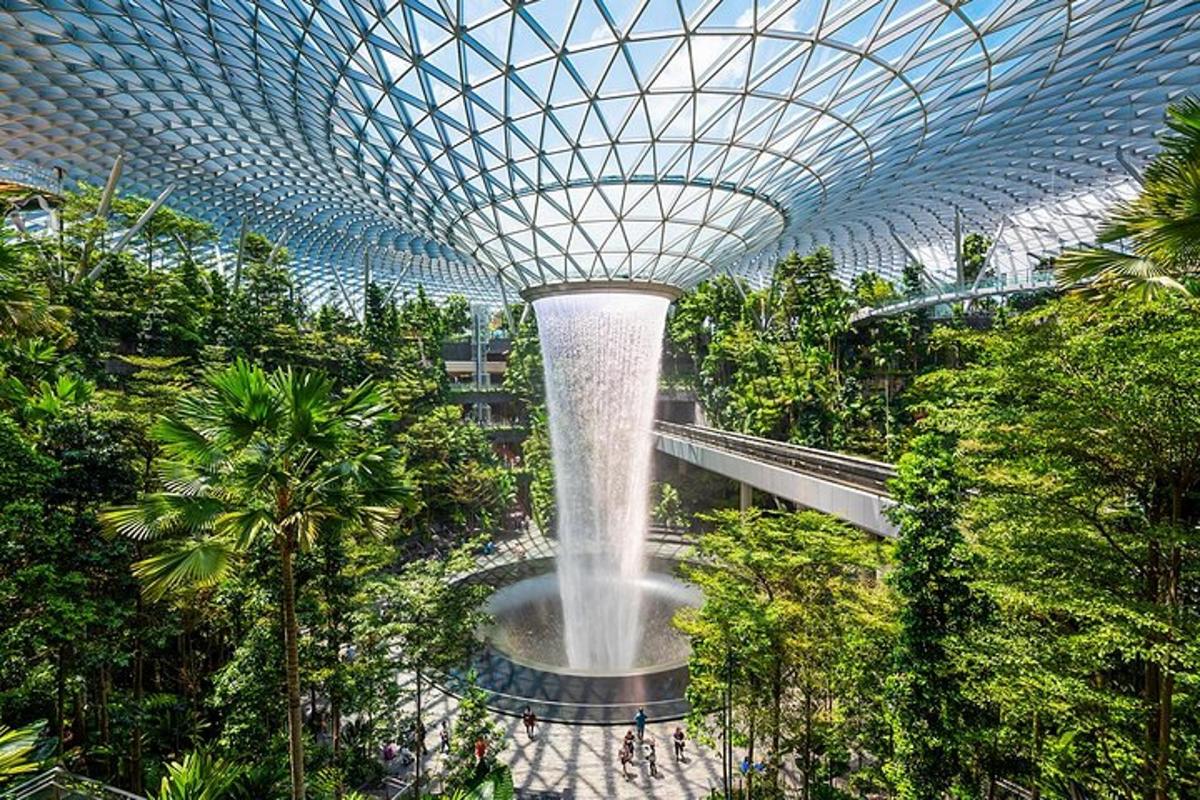 a large fountain in a garden with trees and plants