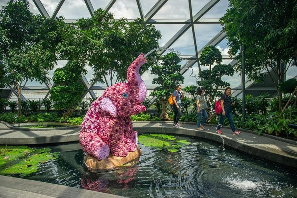 a large pink teddy bear in a pond in a garden