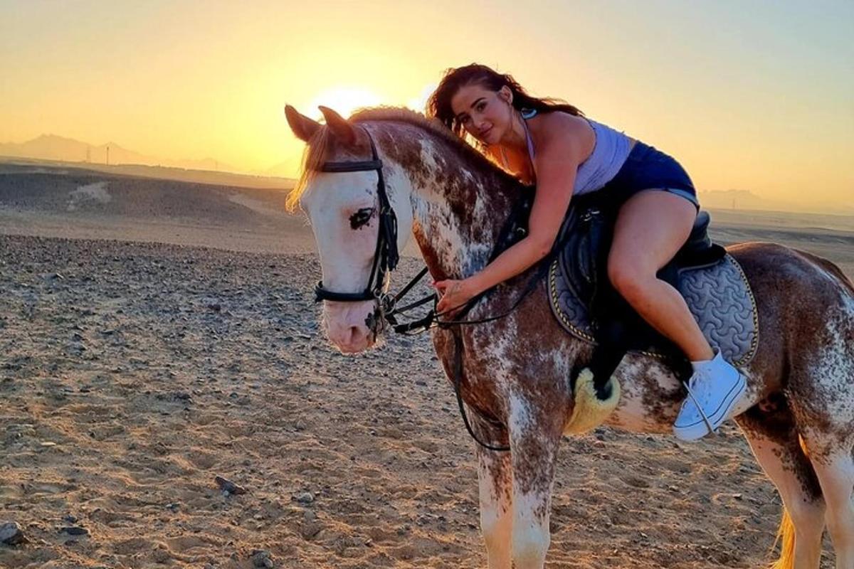 uma mulher cavalgando na praia