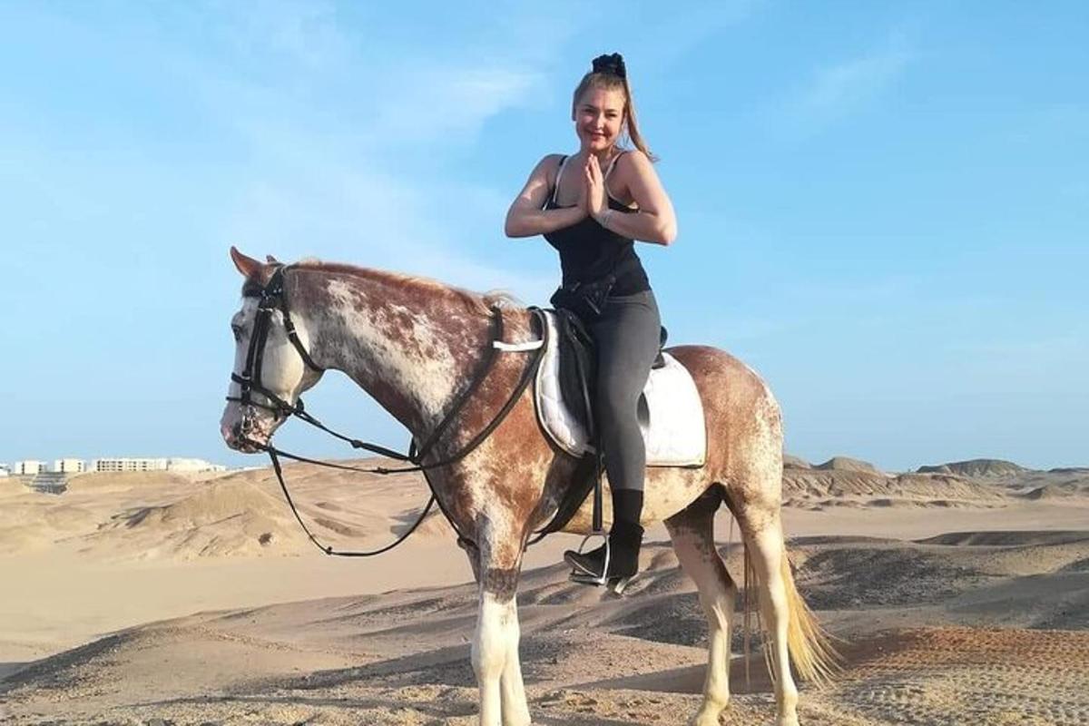 uma mulher sentada em um cavalo no deserto