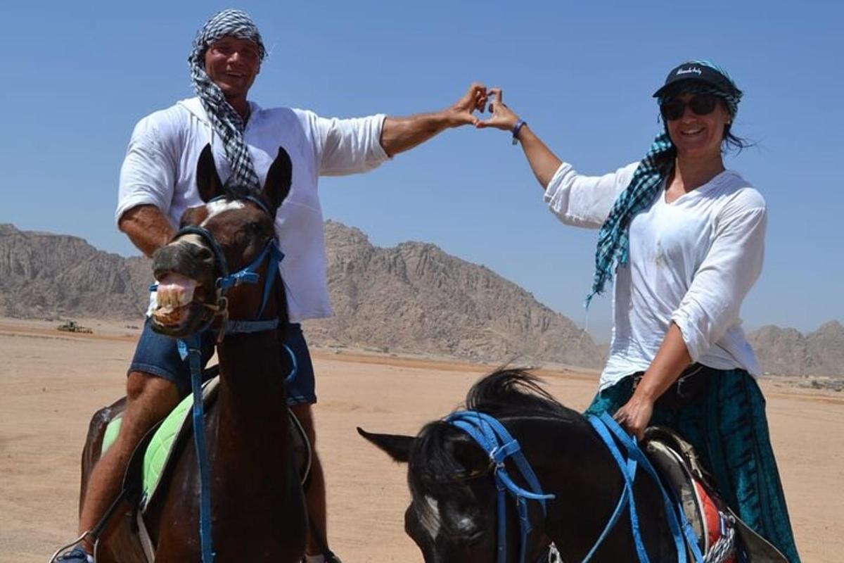 un home i una dona muntant a cavall al desert