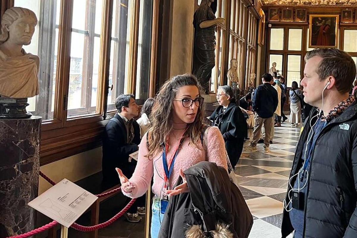 Una mujer parada en un museo mirando una estatua.