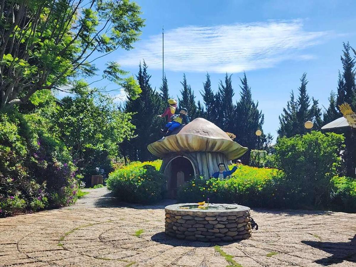 a garden with a mushroom house and a fountain