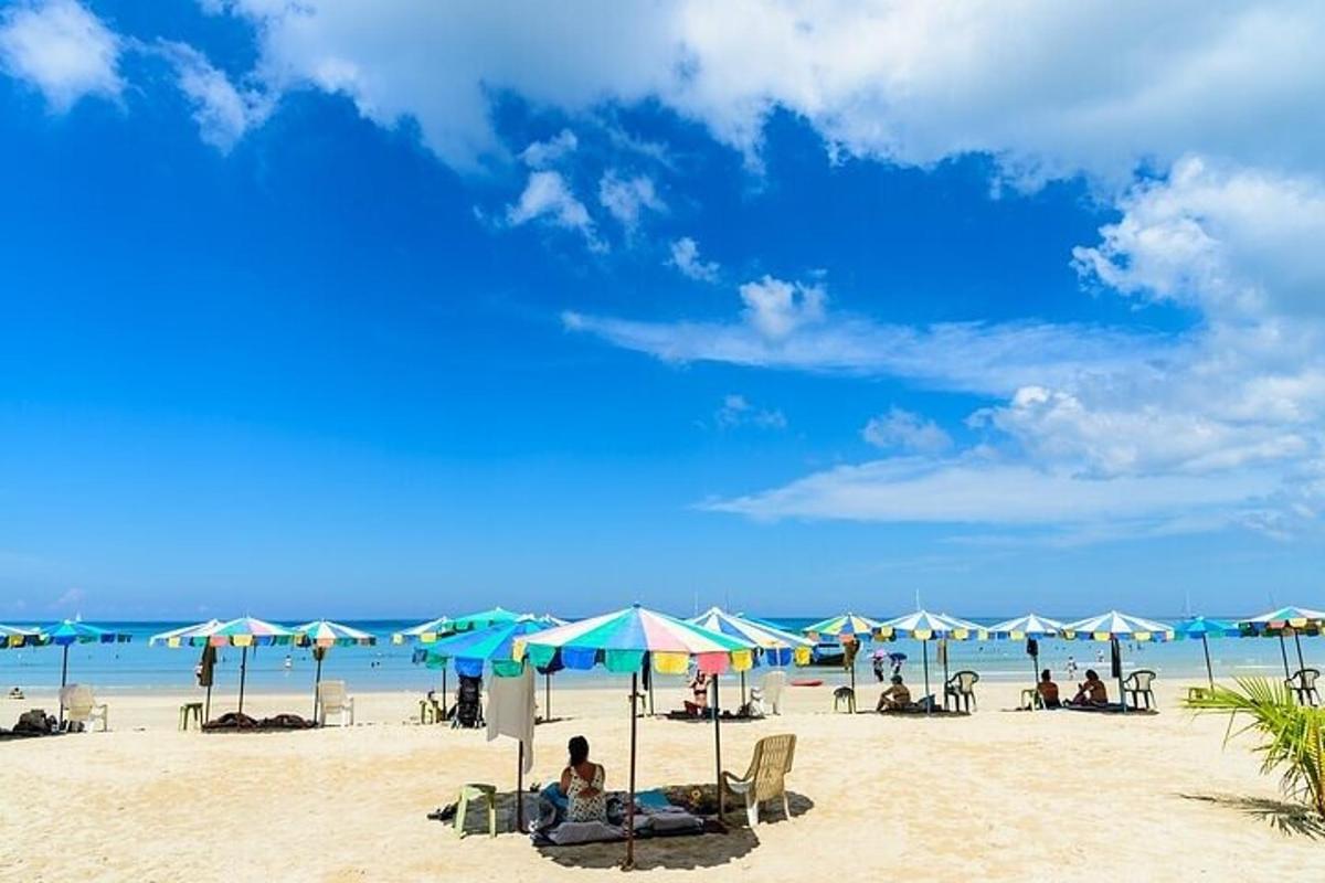 a beach with umbrellas and people sitting on the sand