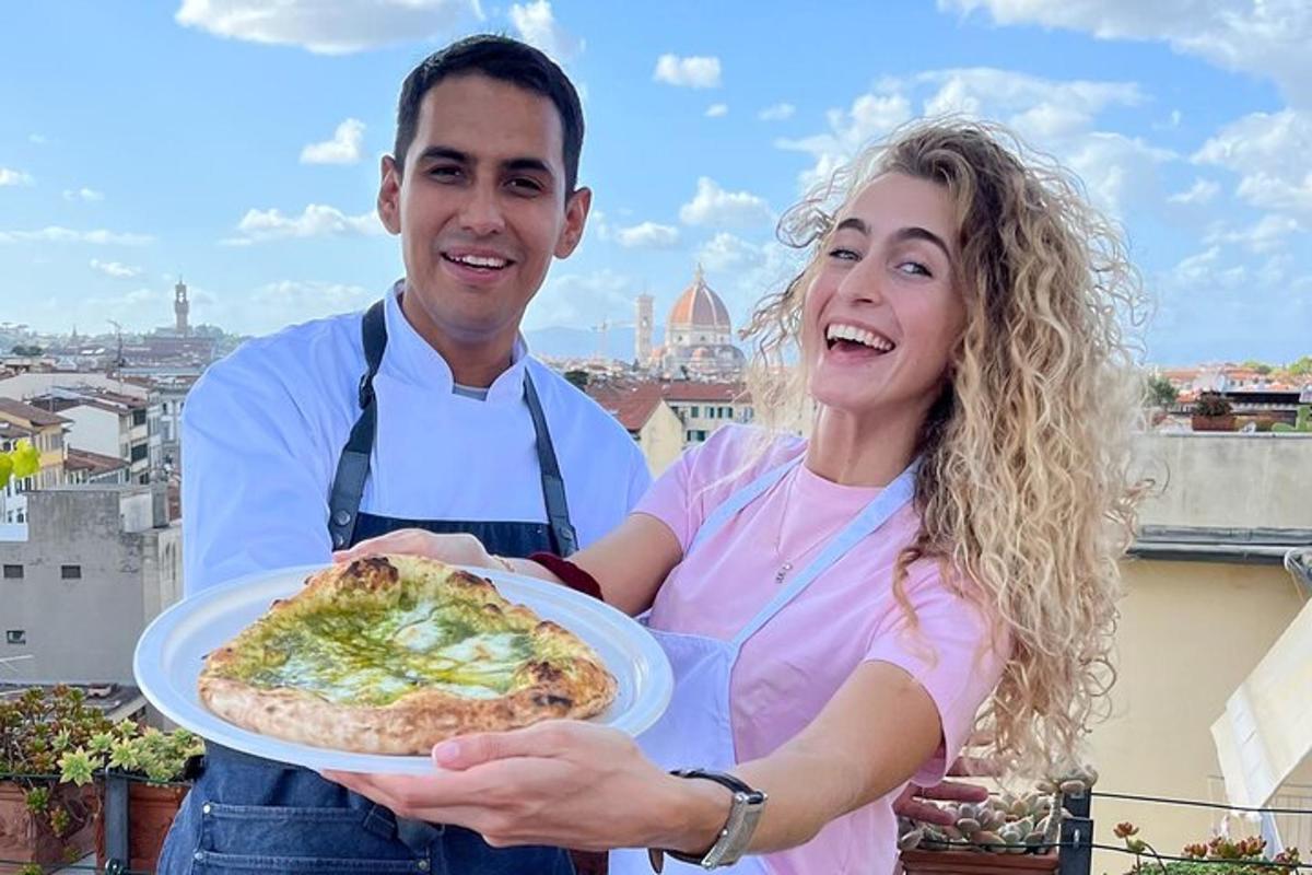 một người đàn ông và một người phụ nữ đang cầm một đĩa pizza