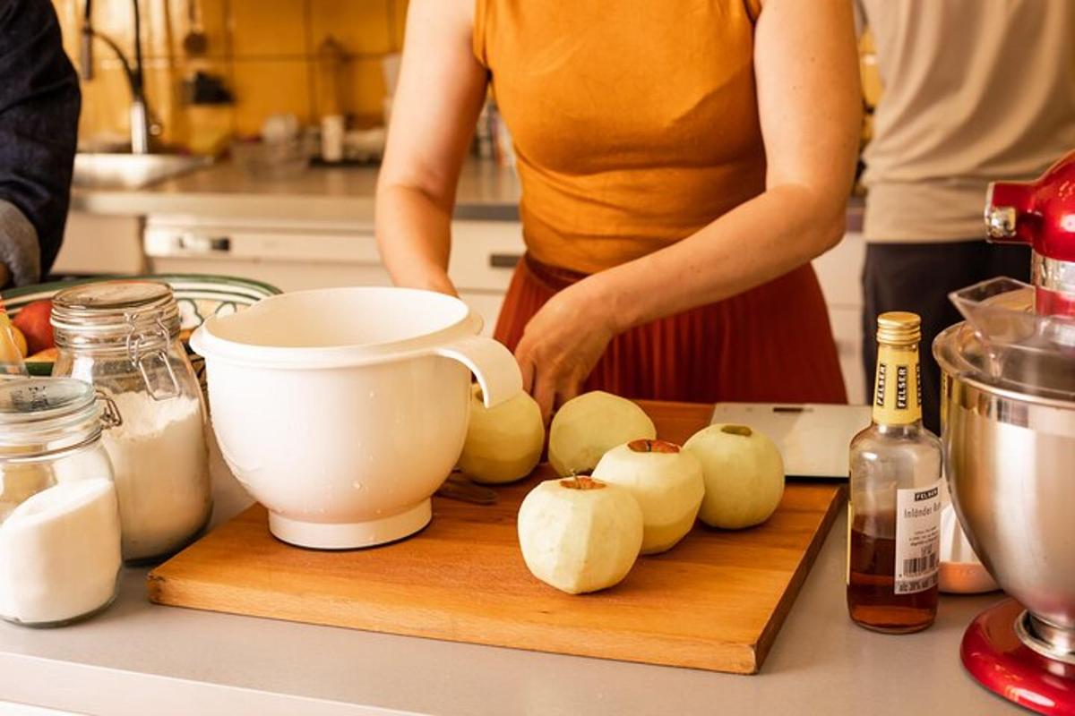 một người phụ nữ đang đứng trong bếp cắt hành tây trên thớt