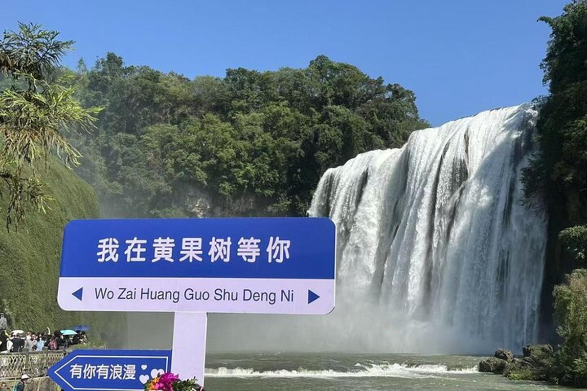a sign in front of a waterfall