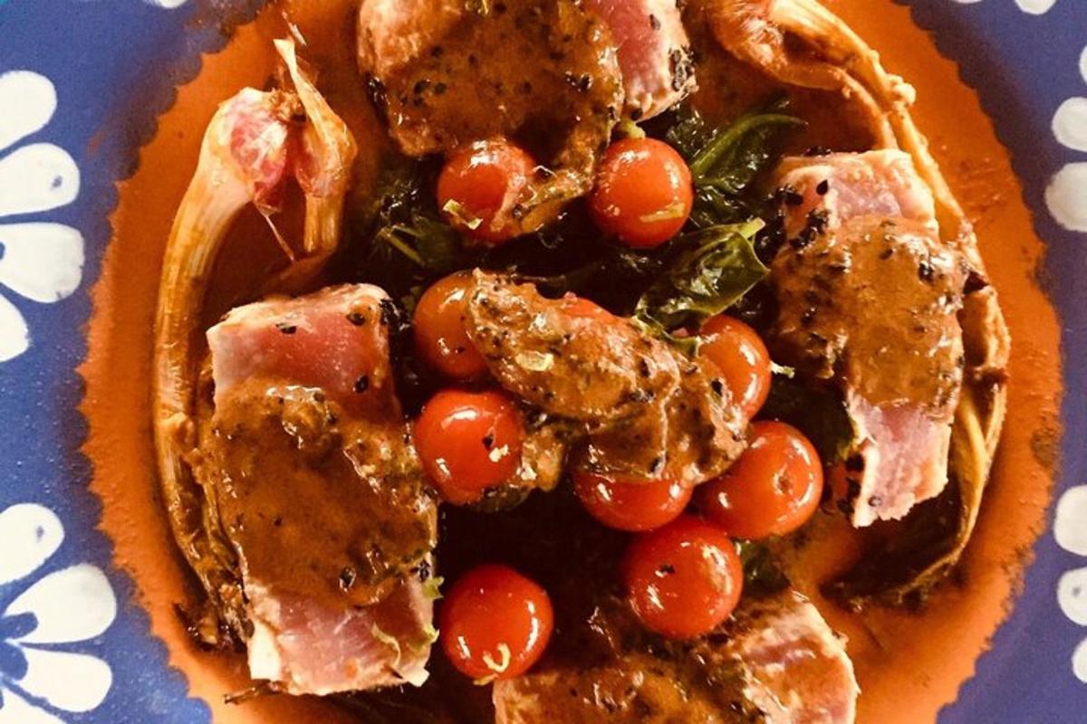 un plato de comida con tomates y carne