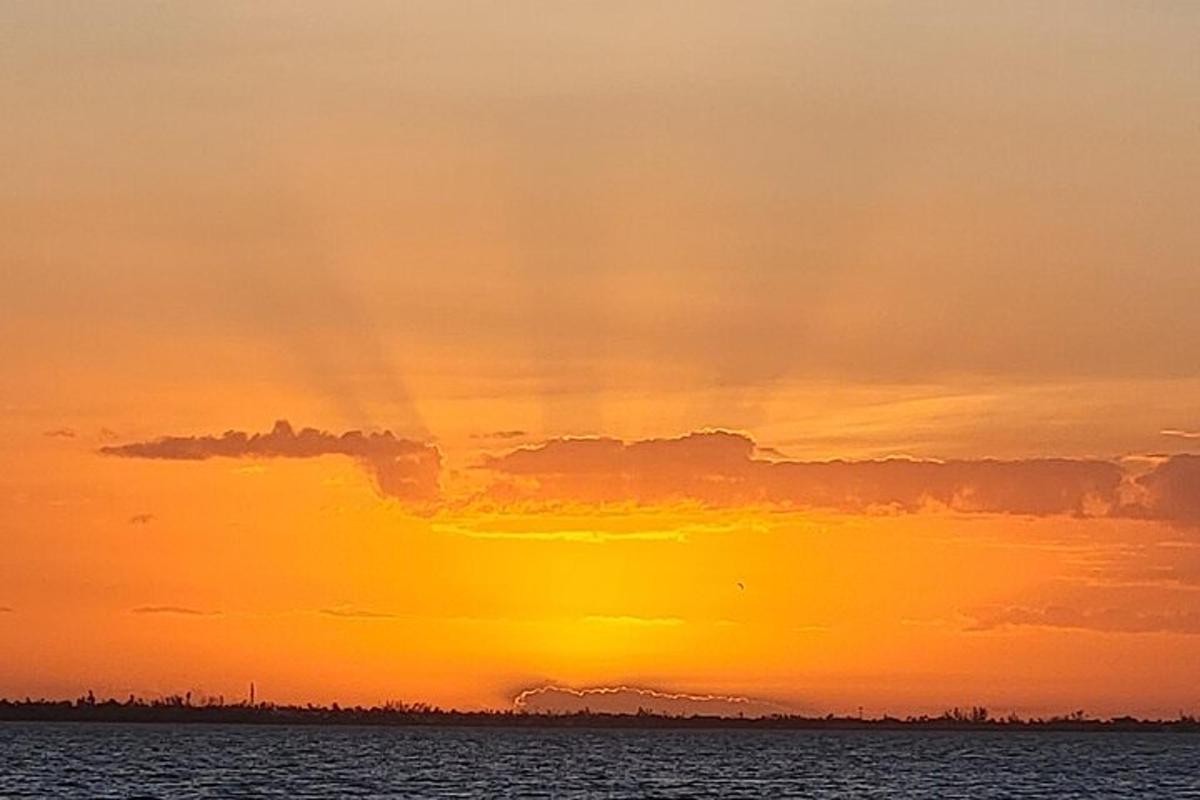 a sunset over a body of water with the sun setting