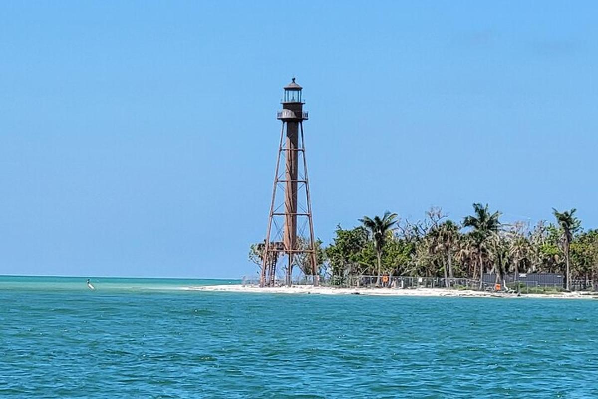 a lighthouse on a beach next to the ocean