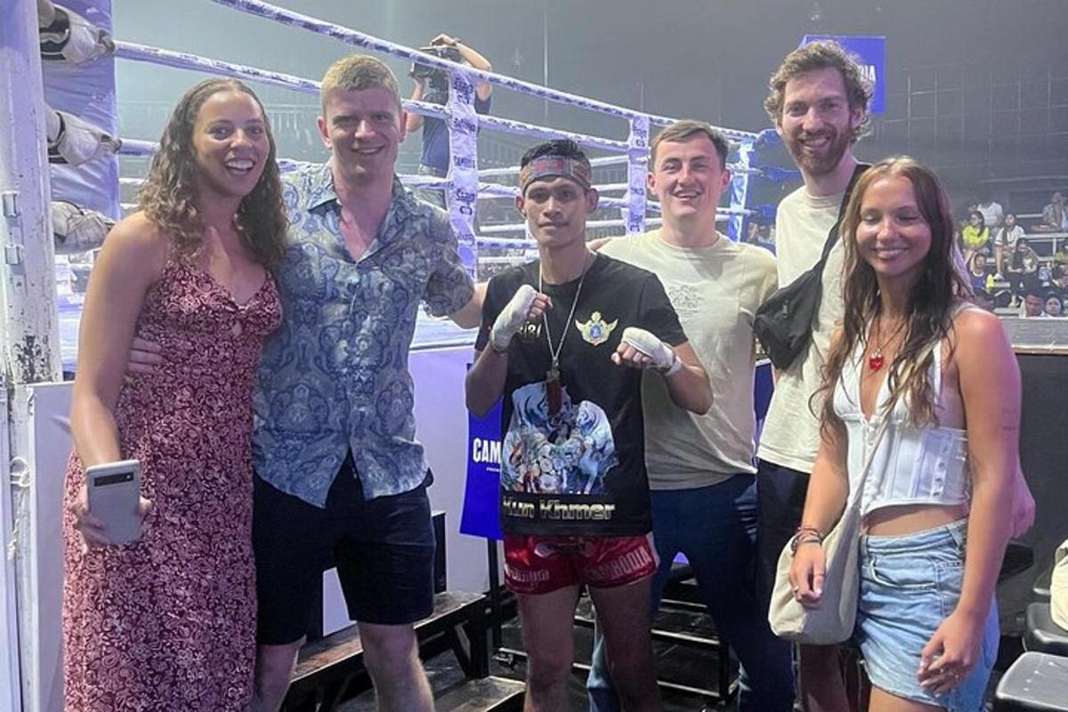 a group of people posing for a picture in a boxing ring