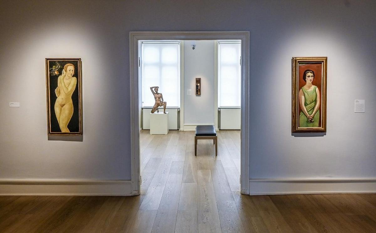a room with paintings on a wall with a chair