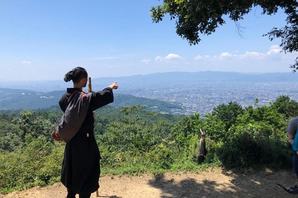 a woman standing on a hill pointing at the city