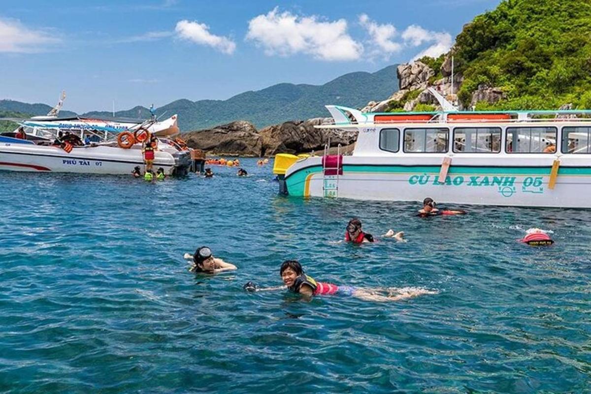 một nhóm người đang bơi trong nước gần một chiếc thuyền