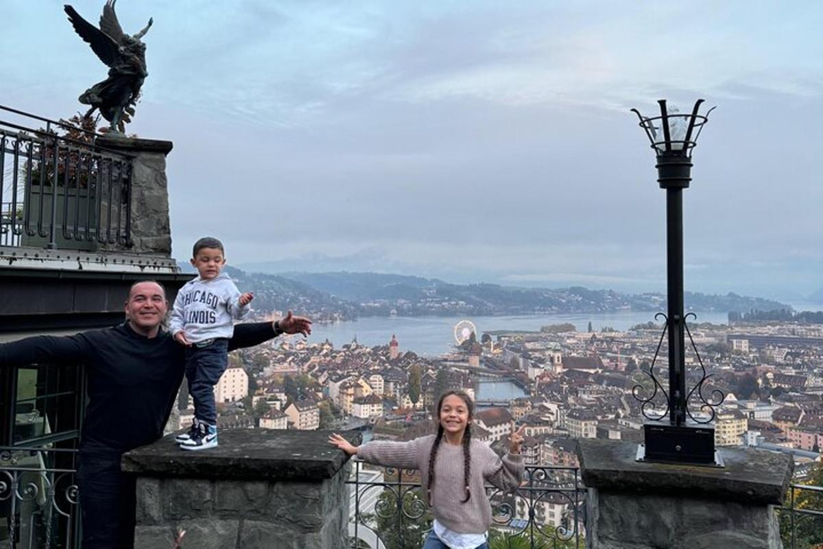 um homem, uma mulher e uma criança em pé em uma torre com uma estátua