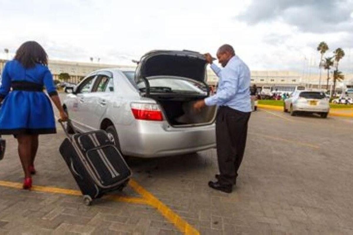 a man putting his luggage into the trunk of a car
