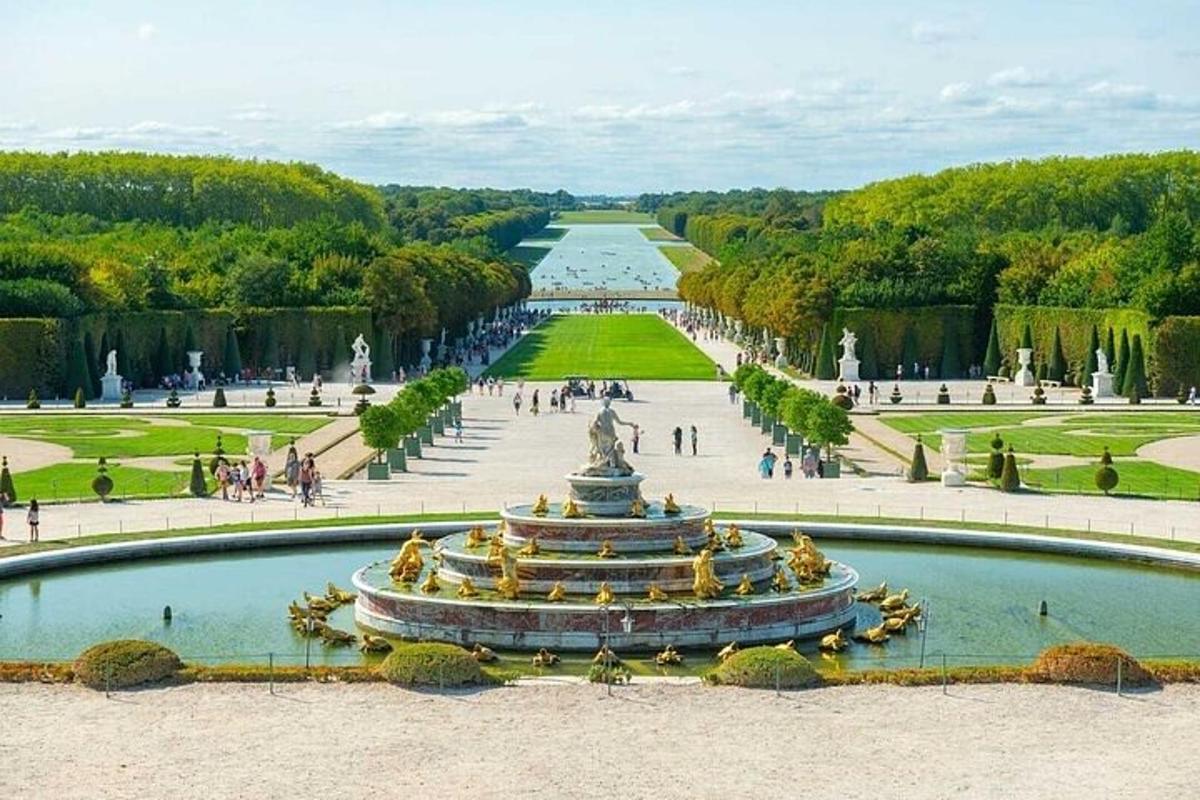 a fountain in a park with people walking around it