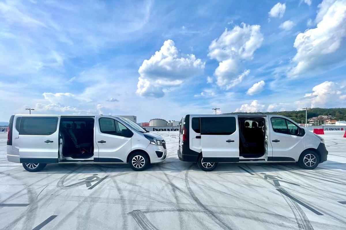 twee witte busjes geparkeerd op een parkeerplaats