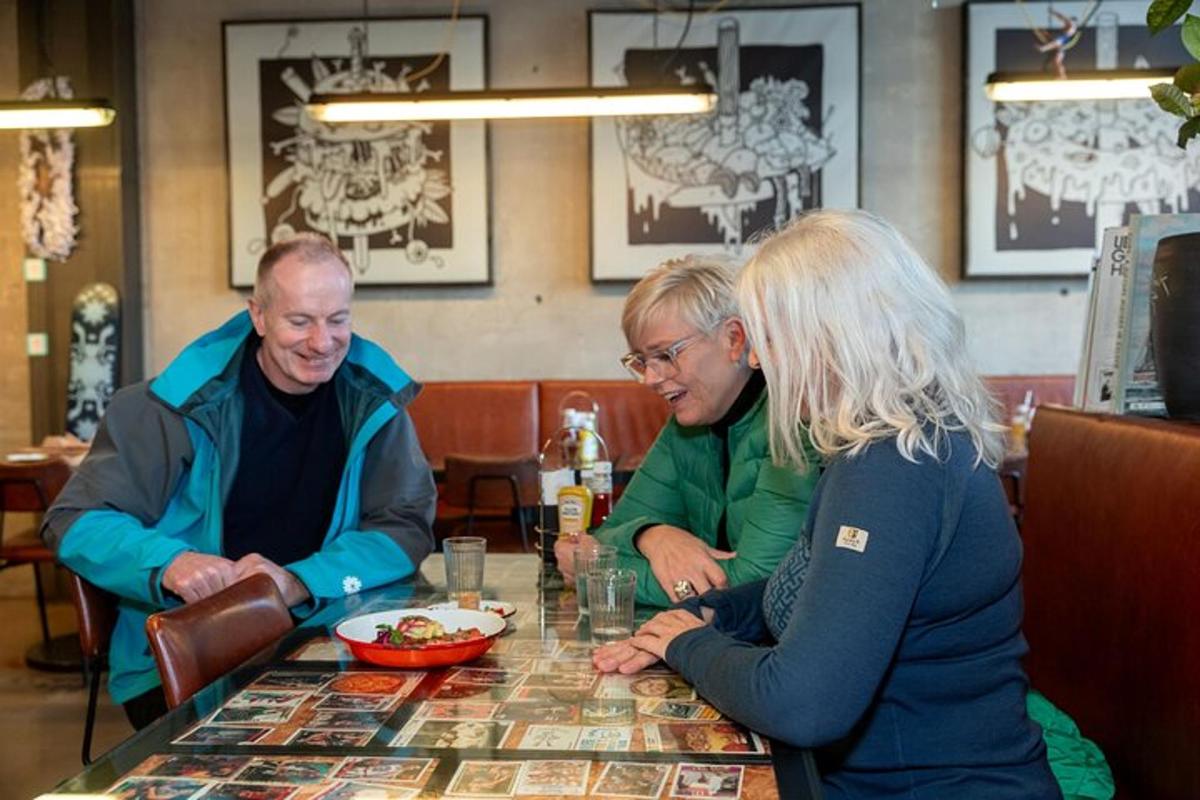tři lidé sedící u stolu v restauraci