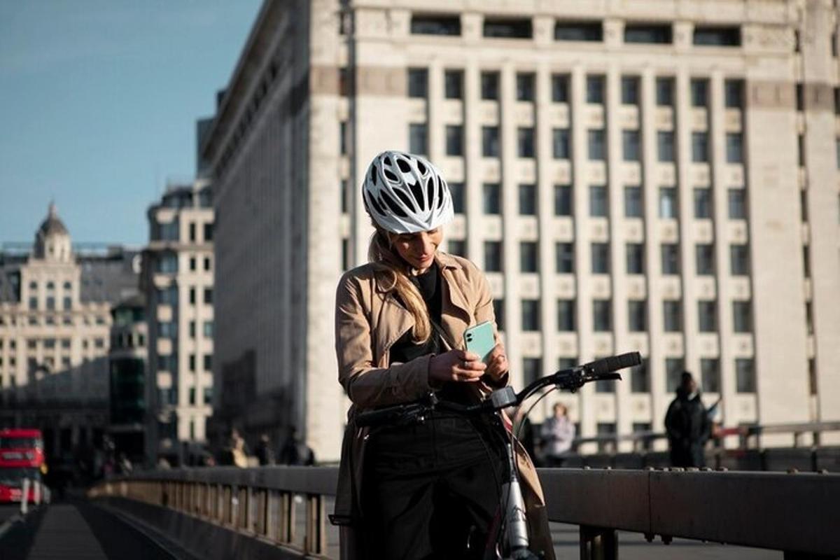 una donna che indossa un casco e guarda il suo cellulare